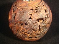 Mexican vintage folk art, a finely carved coconut with scenes from the Mexican Revolution of 1910, c. 1925-35. The carved coconut has the Mexican national emblem of the eagle and snake inlaid in abalone. Photo of back of carved coconut.